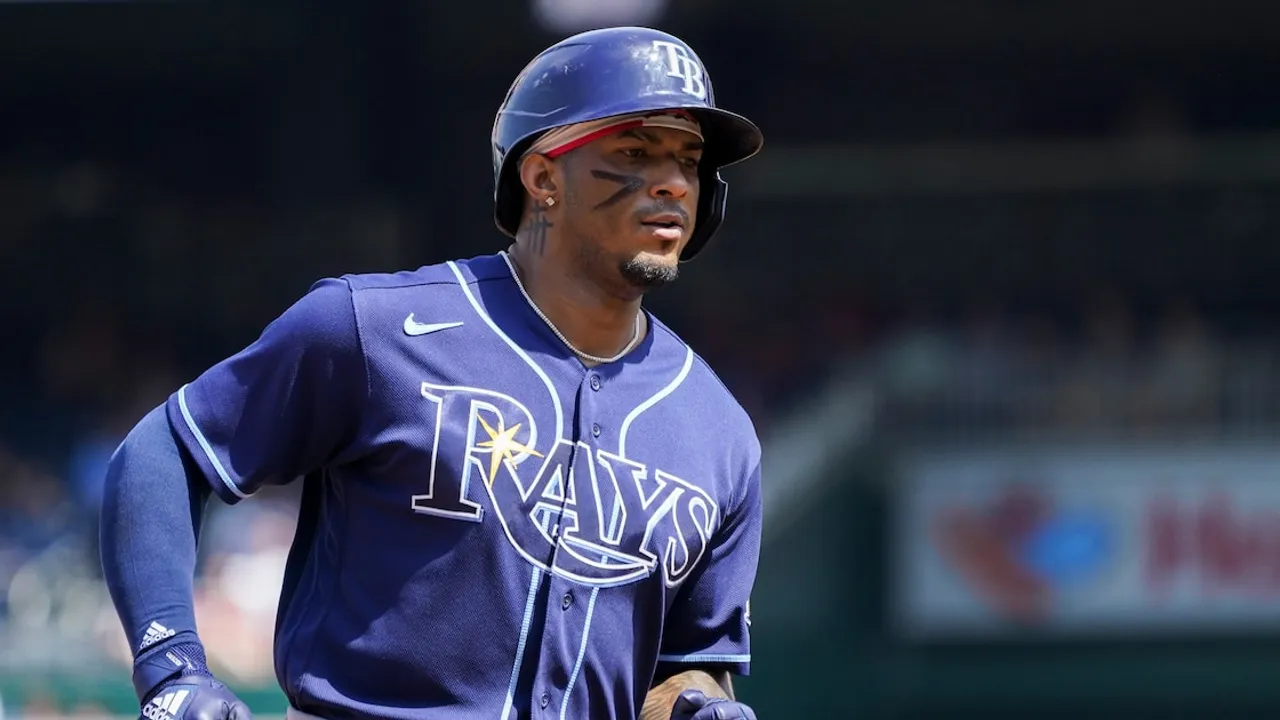Beisbolista con casco y uniforme azul de los Rays corre en el campo durante un partido