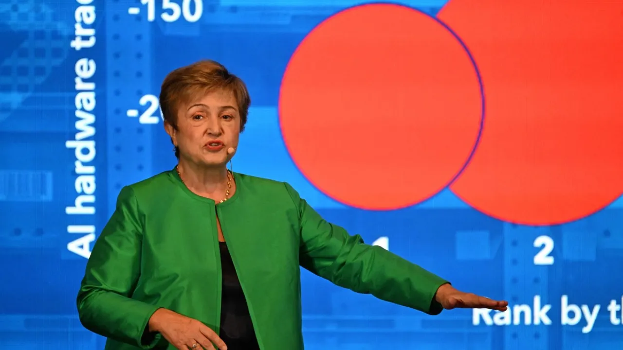 Kristalina Georgieva habla en un escenario frente a una pantalla azul con gráficos de círculos rojos.