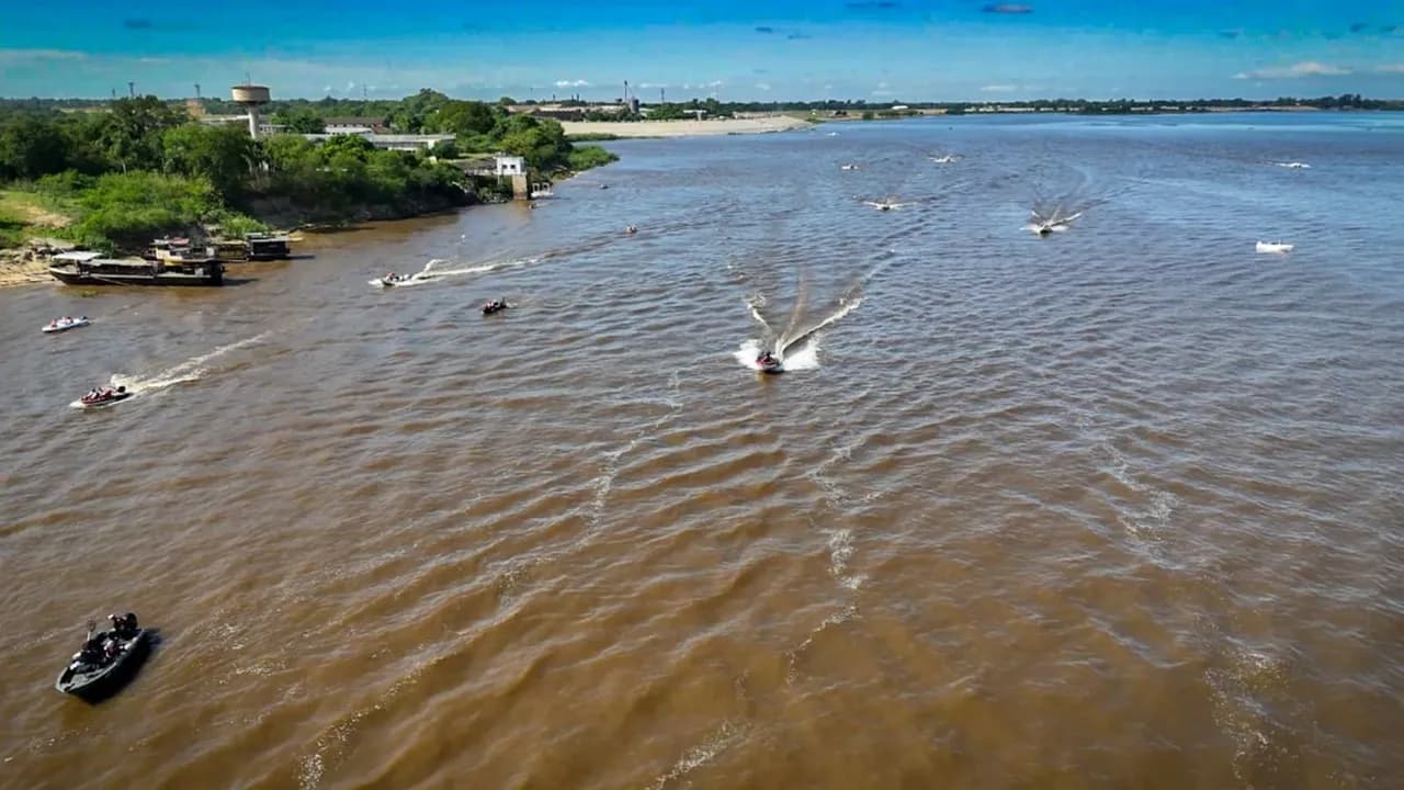 Embarcaciones a motor navegan sobre un caudaloso río mientras realizan tareas de patrullaje fluvial.