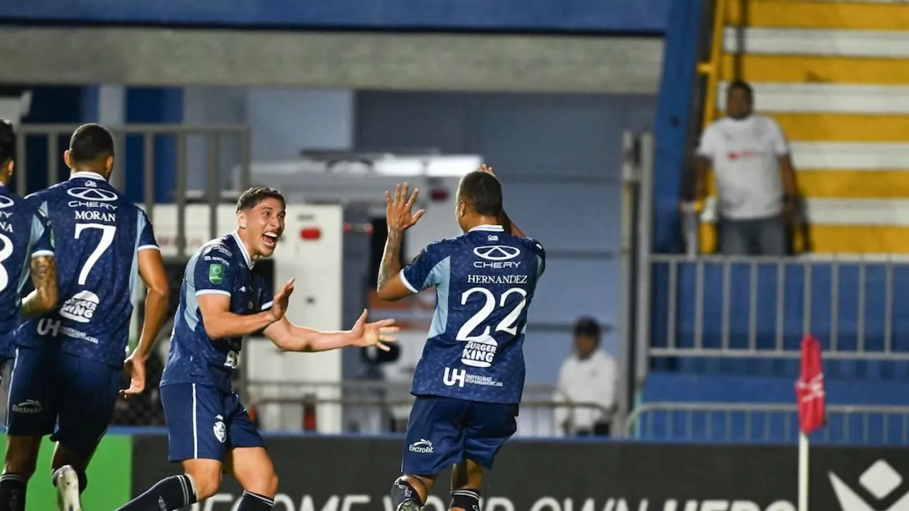 Futbolistas del Cartaginés con uniforme azul celebran un gol sonriendo y levantando las manos en la cancha
