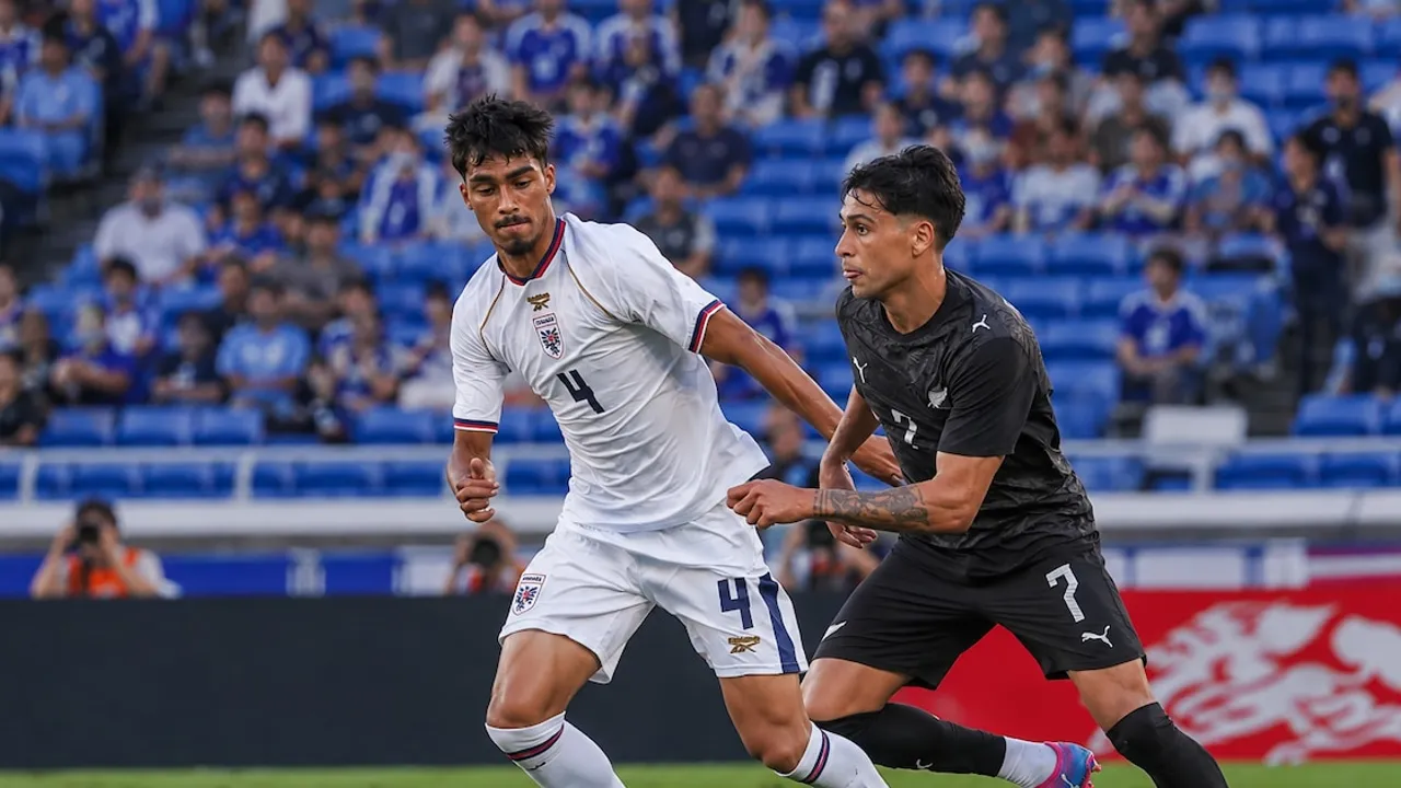 Dos futbolistas disputan la pelota en velocidad sobre el césped durante un partido internacional en un estadio.