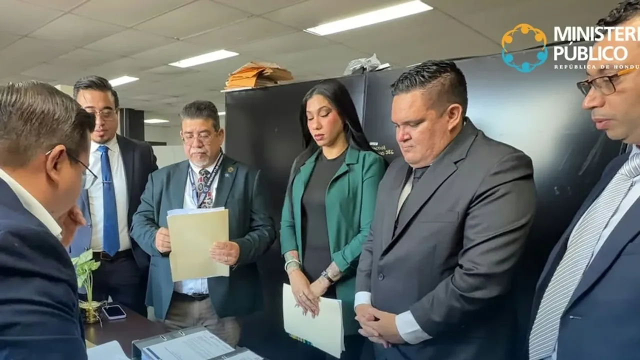Integrantes de una comitiva con trajes formales presentan carpetas y documentos legales frente a un escritorio de oficina.