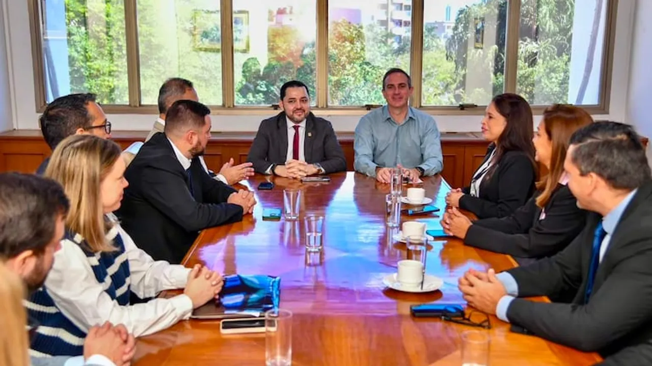 Autoridades y técnicos reunidos en torno a una mesa de madera durante una sesión de trabajo municipal.
