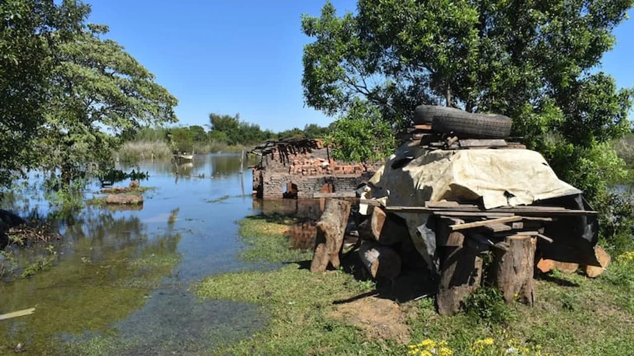 Horno de ladrillos y maderas anegados por el desborde de las aguas del río bajo cielo despejado en Ayolas.