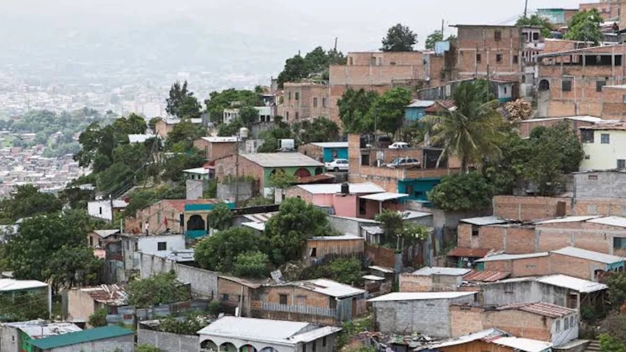 Panorámica de viviendas precarias construidas sobre laderas empinadas en una zona urbana densamente poblada