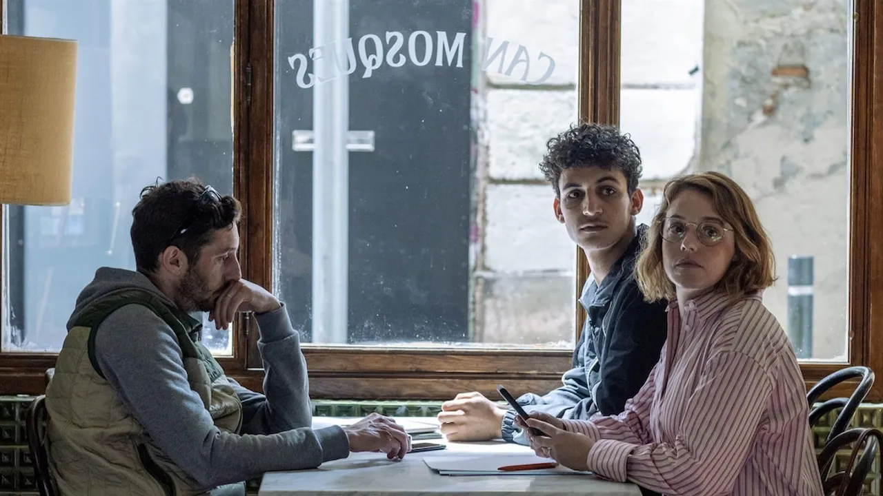 Tres personas sentadas junto a la ventana de un local gastronómico mirando hacia el interior del recinto