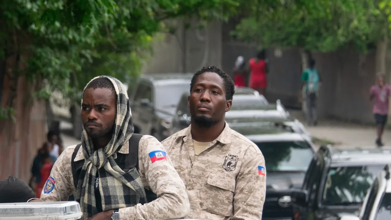 Agentes de la Policía Nacional de Haití patrullan en un vehículo militar con uniformes camuflados en una calle urbana.