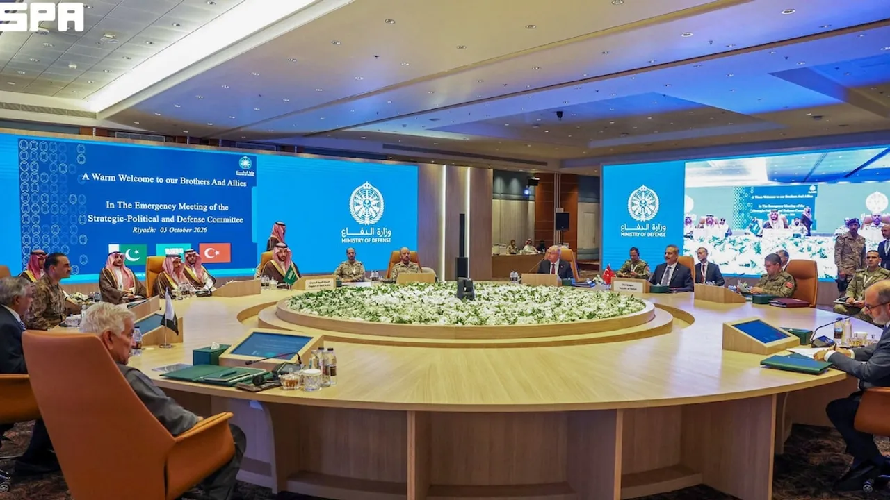 Delegaciones oficiales sentadas alrededor de una gran mesa circular durante una reunión ministerial de defensa en un salón.