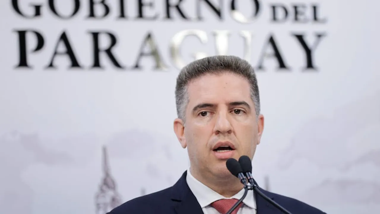 Gustavo Villate hablando frente a dos micrófonos ante un fondo institucional del Gobierno del Paraguay.
