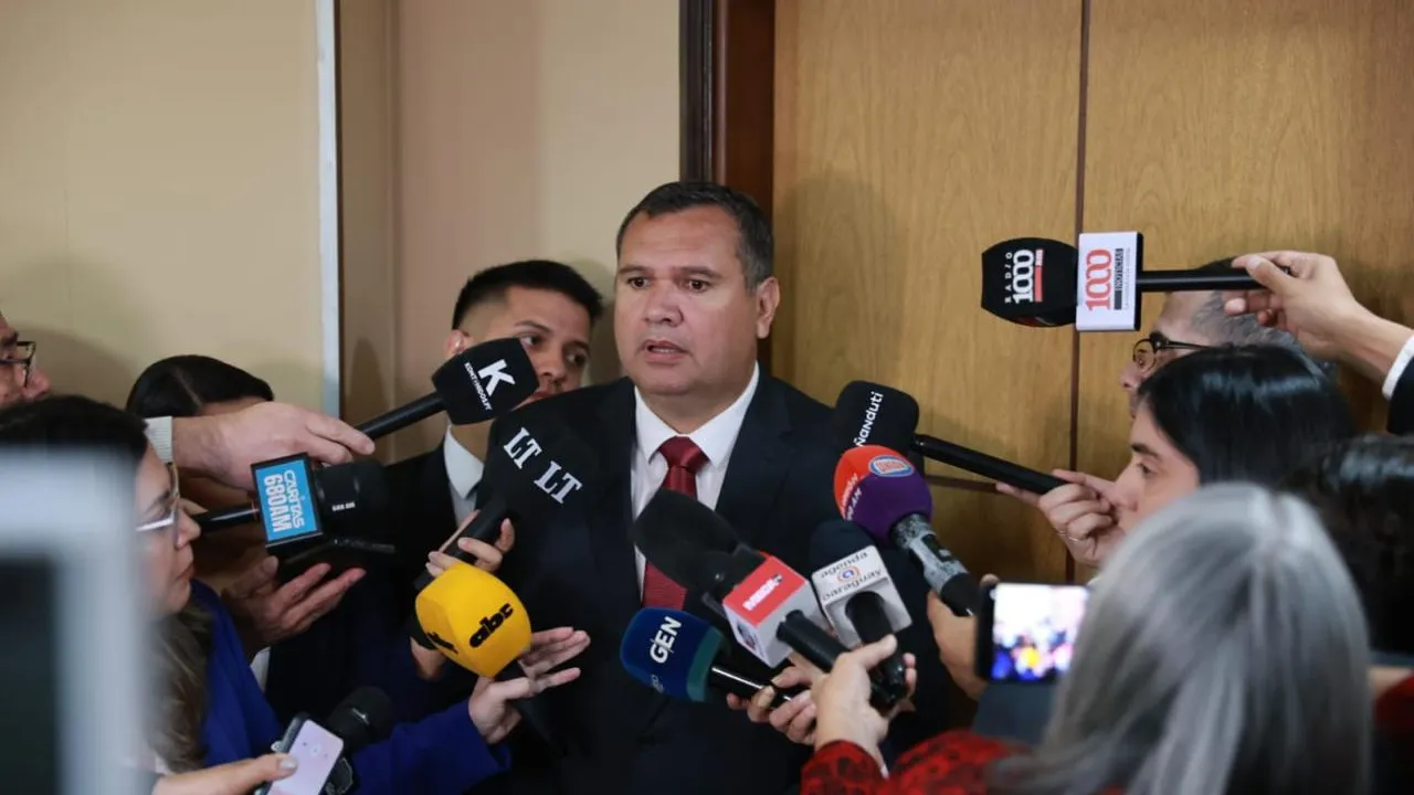 Derlis Maidana habla frente a numerosos micrófonos y grabadores de periodistas durante una conferencia de prensa.