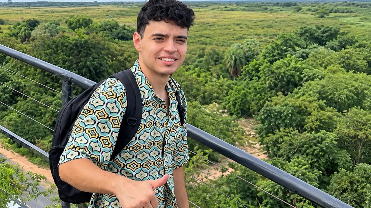 Bruno Ojeda sonríe con el pulgar arriba vistiendo camisa estampada ante un paisaje verde