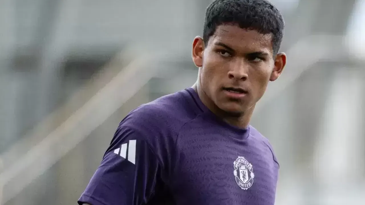 Joven futbolista con remera morada del Manchester United mirando hacia un costado durante un entrenamiento.
