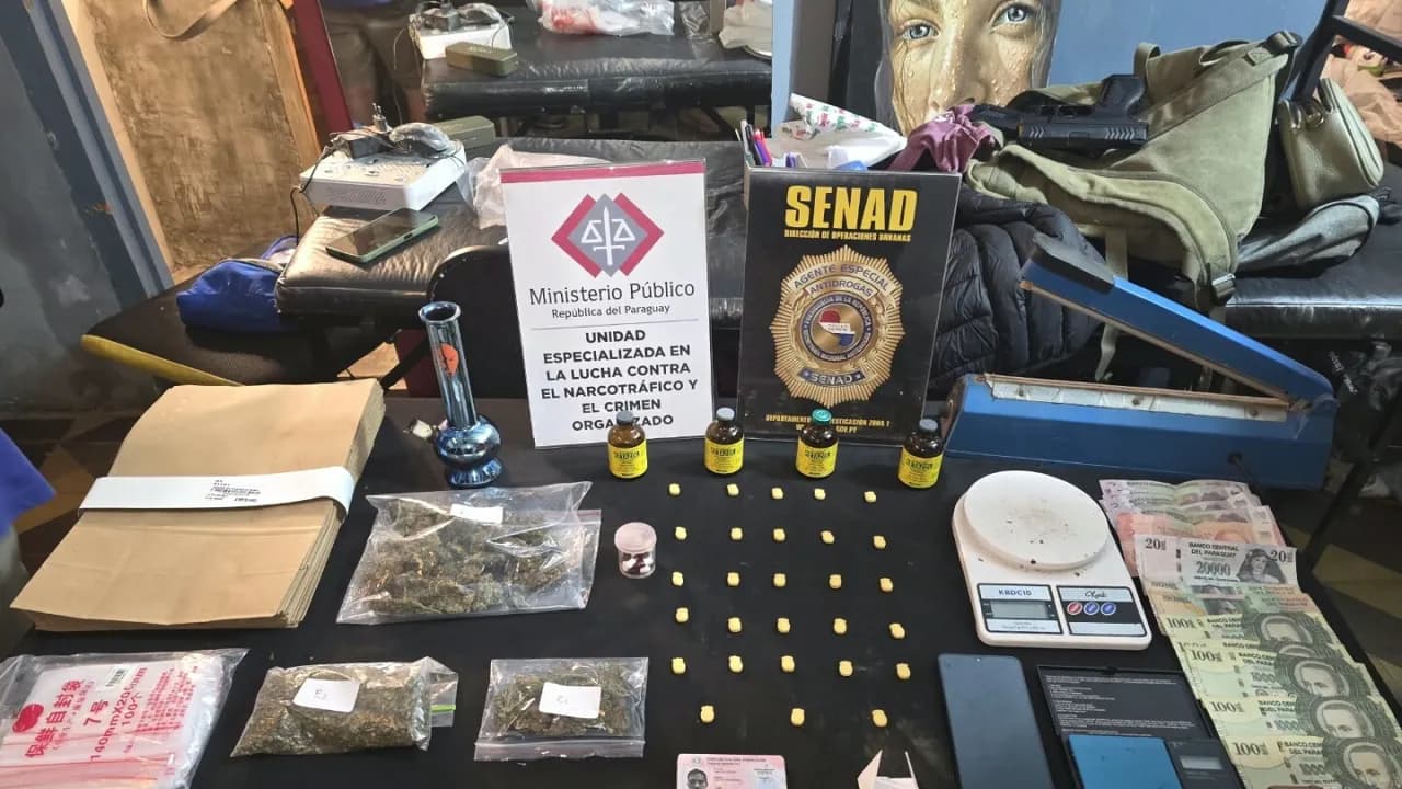 Mesa con drogas incautadas, pastillas, marihuana, ketamina, balanzas de precisión y dinero junto a carteles de la Senad.