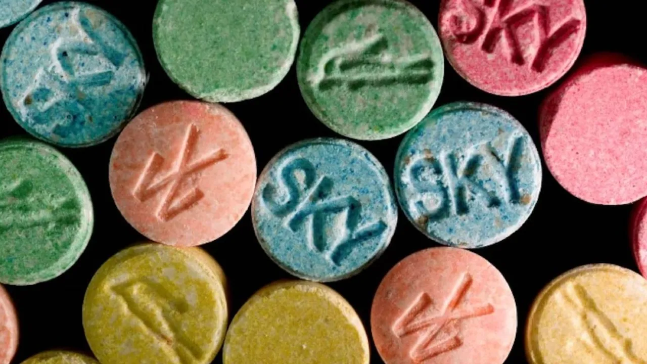 Pastillas redondas de colores verde, azul, rosado y amarillo con grabados y letras sobre fondo negro