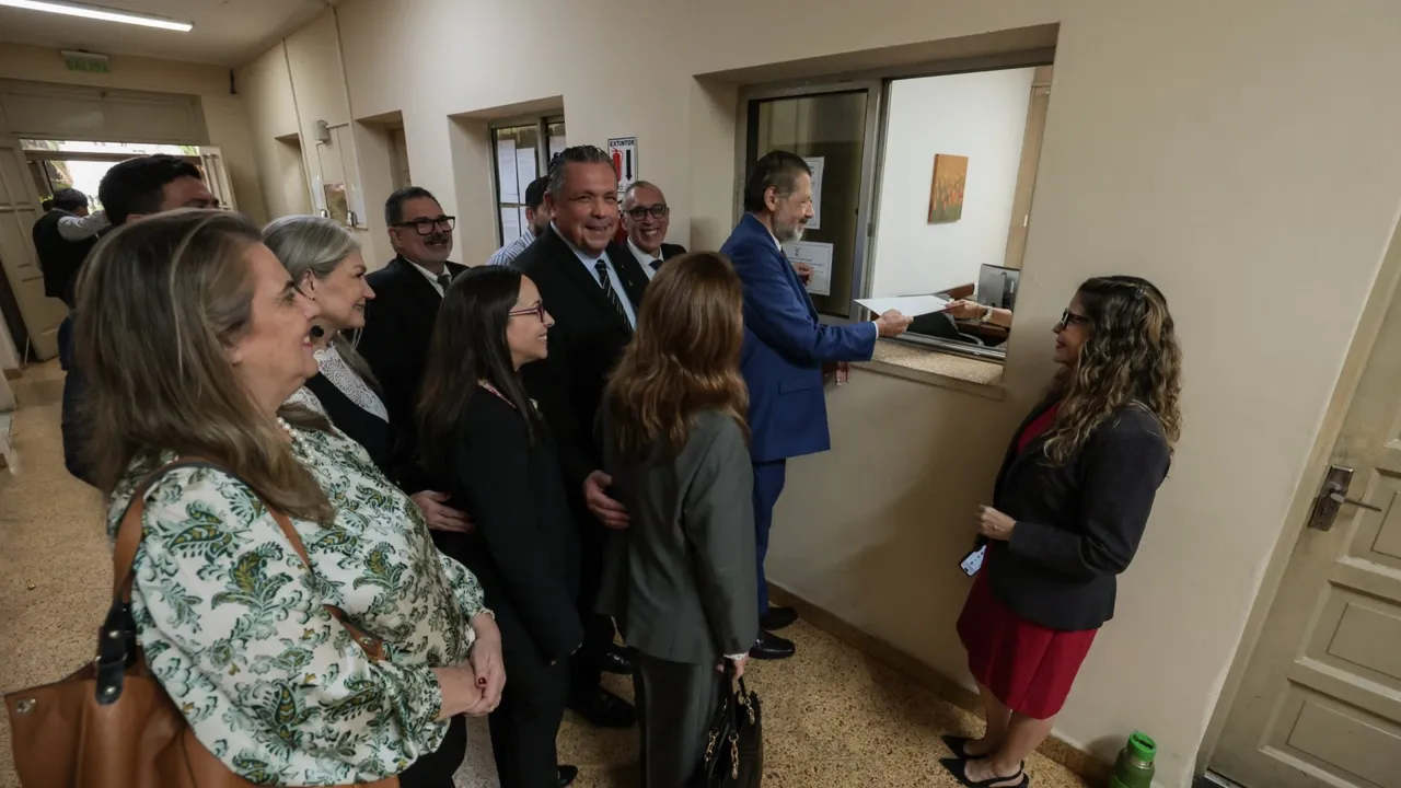 Grupo de abogados presenta documentos ante la ventanilla de atención de una oficina judicial institucional.