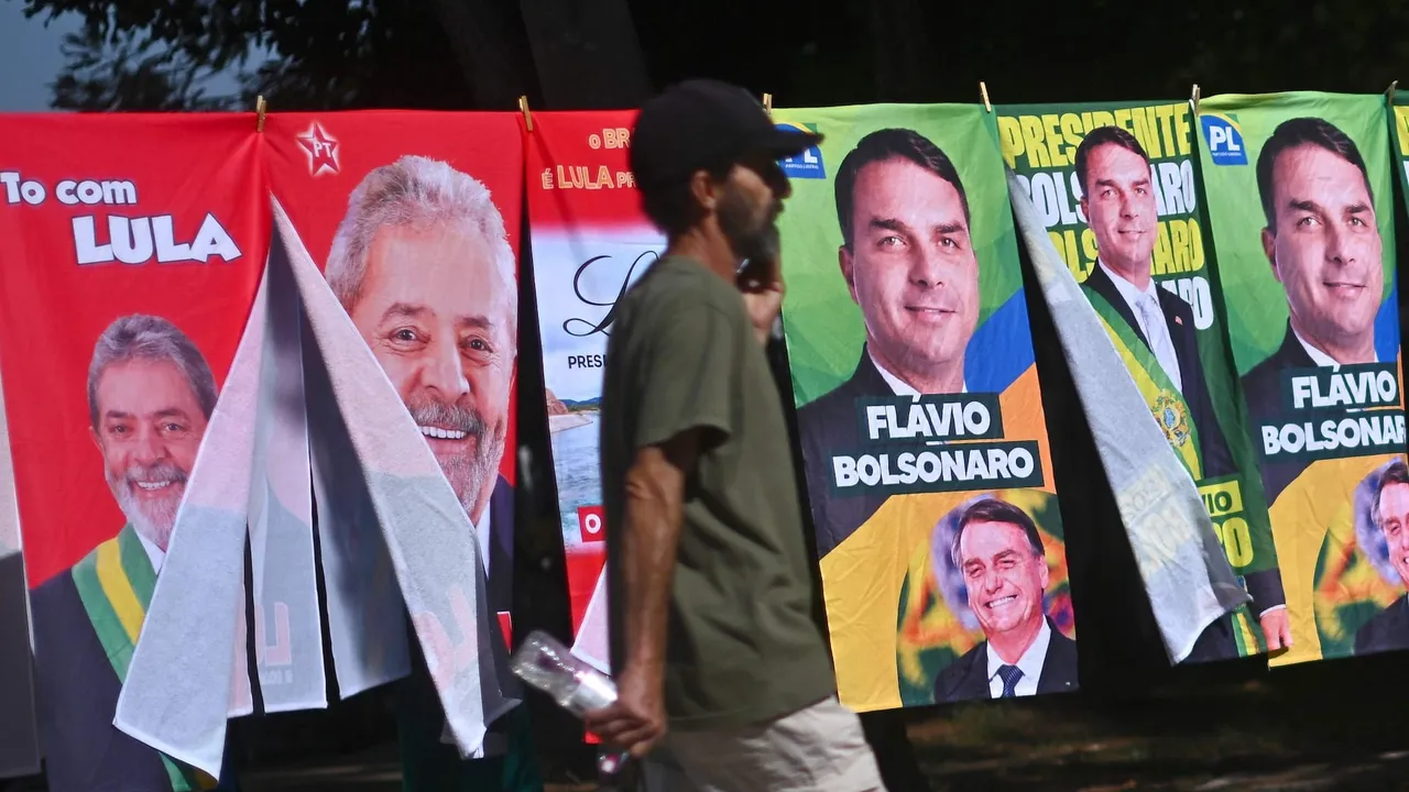 Puesto con toallas electorales de candidatos de Brasil colgadas y un hombre caminando frente a los carteles