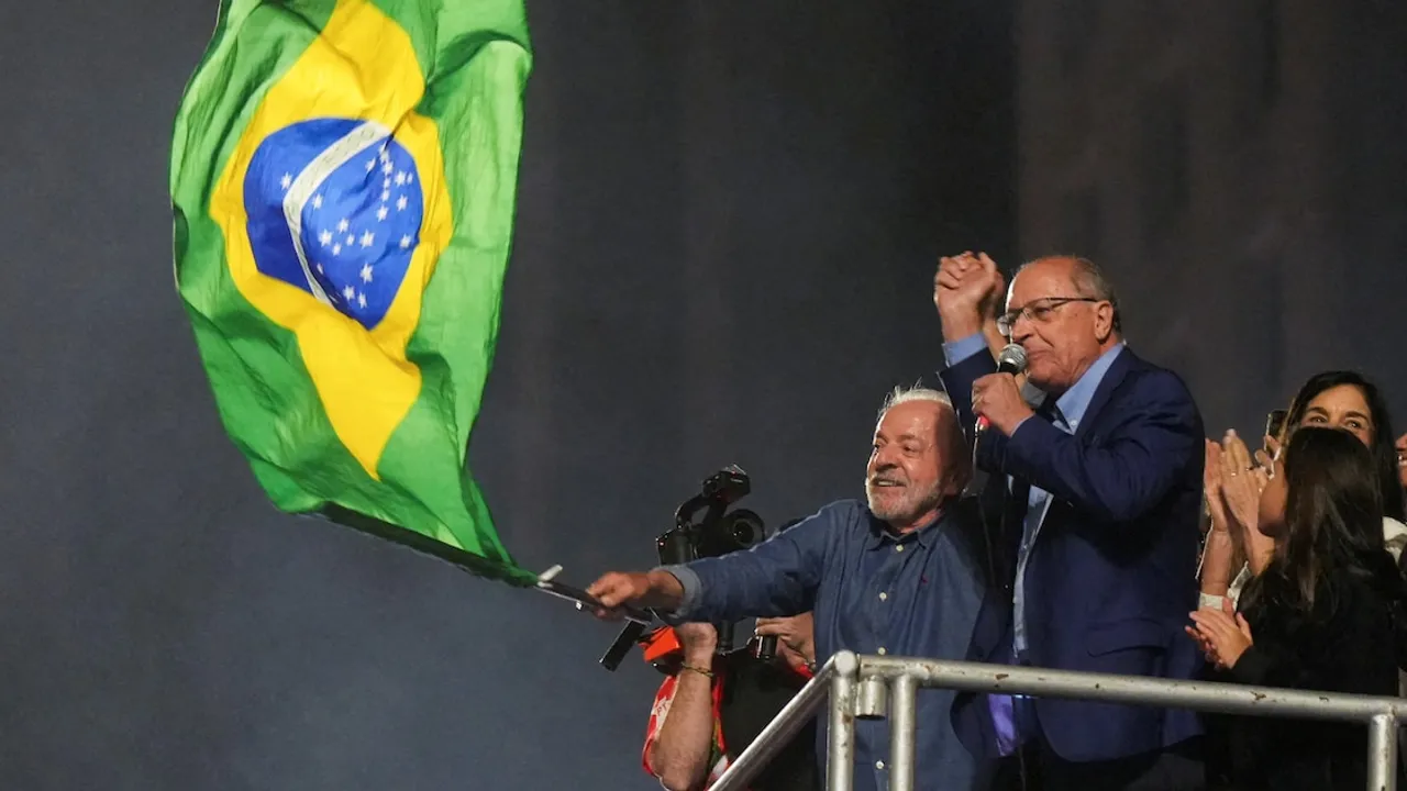 Luiz Inácio Lula da Silva agita una bandera de Brasil junto a Geraldo Alckmin en un escenario político.
