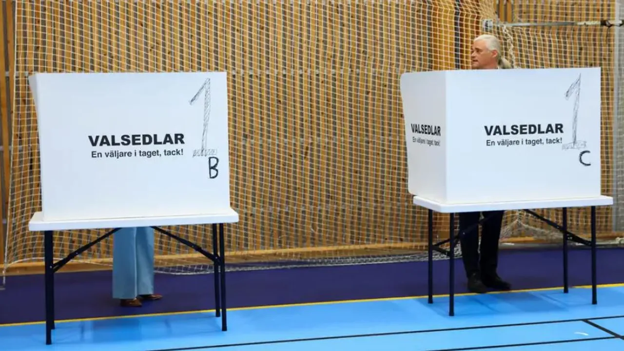 Personas detrás de cabinas de votación de cartón blanco con números y textos en un centro electoral.