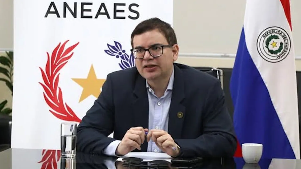 José Duarte Penayo, titular de ANEAES, habla sentado ante una mesa con bandera paraguaya y logo institucional detrás.