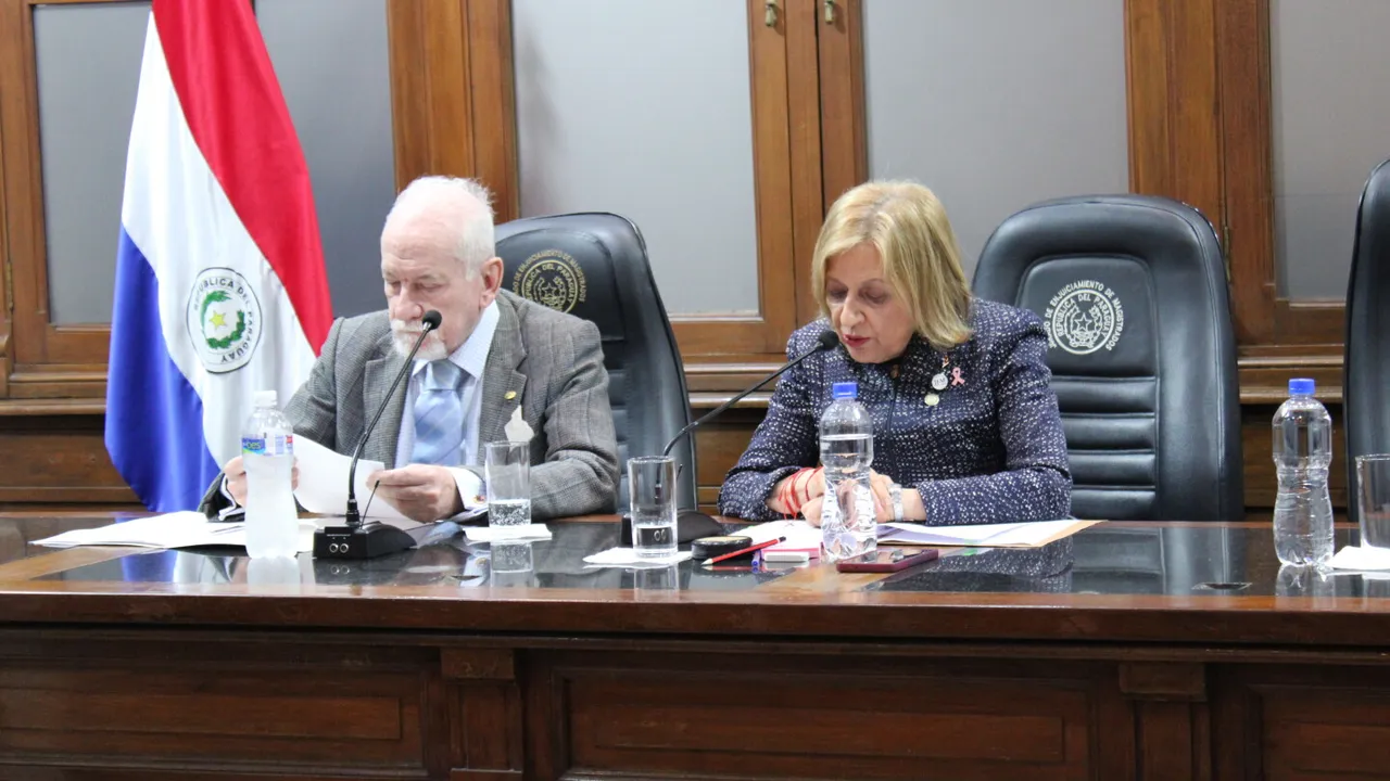 Dos integrantes del Jurado de Enjuiciamiento de Magistrados sentados en una mesa oficial con micrófonos.