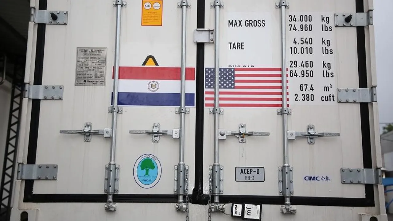 Contenedor de transporte refrigerado con las banderas de Paraguay y Estados Unidos pegadas en sus puertas metálicas.