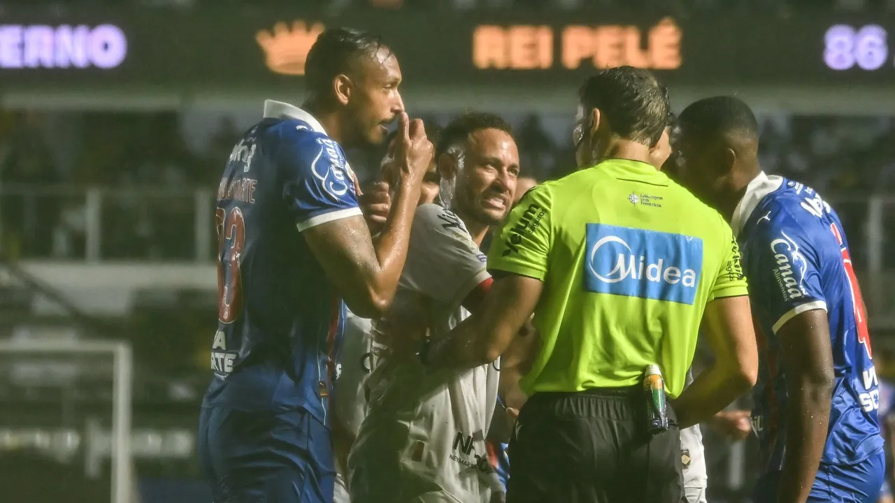 Futbolistas dialogan de manera tensa frente a un árbitro durante un partido en el estadio de fútbol