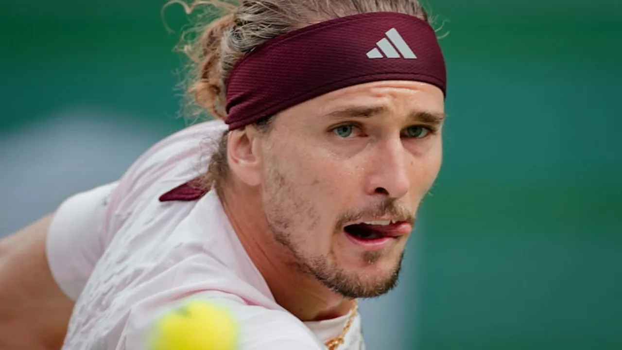 Sascha Zverev con vincha deportiva granate y camiseta blanca concentrado en pleno partido sobre pista de tenis.
