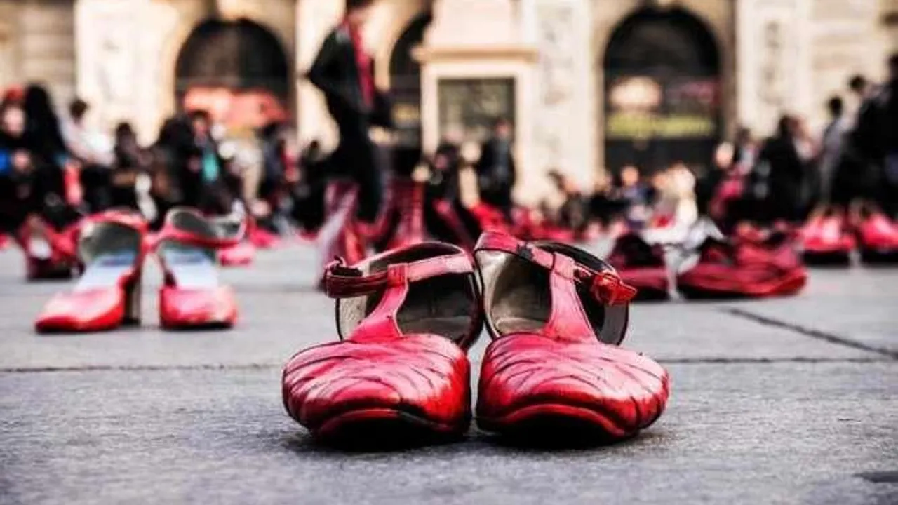 Zapatos de mujer de color rojo dispuestos en una plaza pública durante una manifestación al aire libre.
