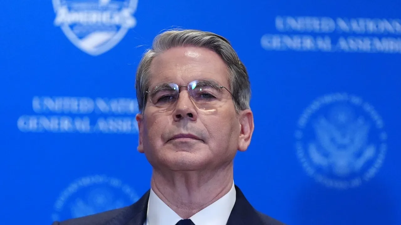 Scott Bessent con anteojos y traje oscuro posa frente a un panel azul de la Asamblea General de la ONU.