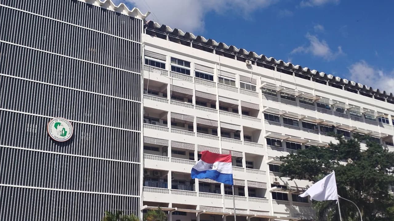 Fachada del edificio del Instituto de Previsión Social con la bandera paraguaya y el logotipo institucional.