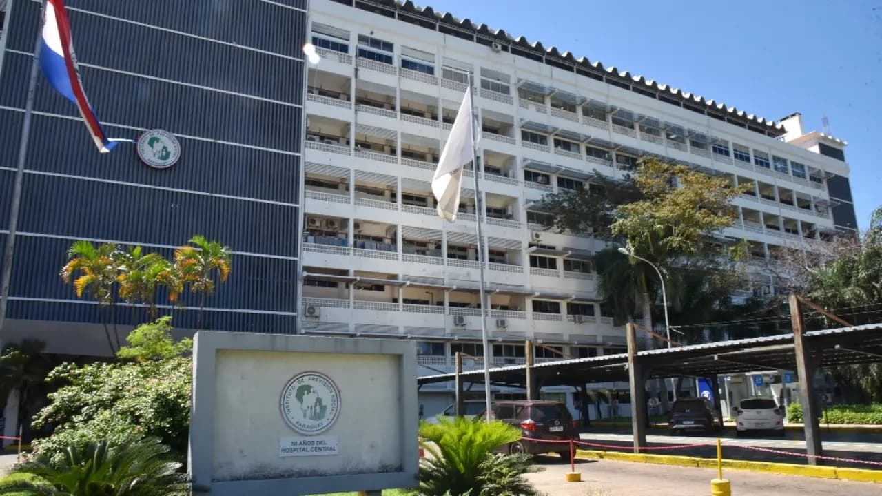 Fachada del Hospital Central del Instituto de Previsión Social con su letrero conmemorativo en primer plano.