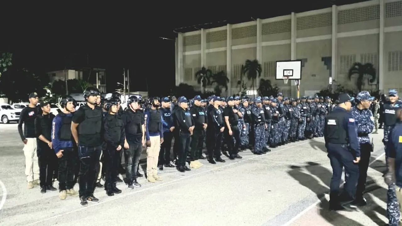 Agentes policiales y migratorios uniformados formados en una cancha deportiva durante un operativo nocturno.