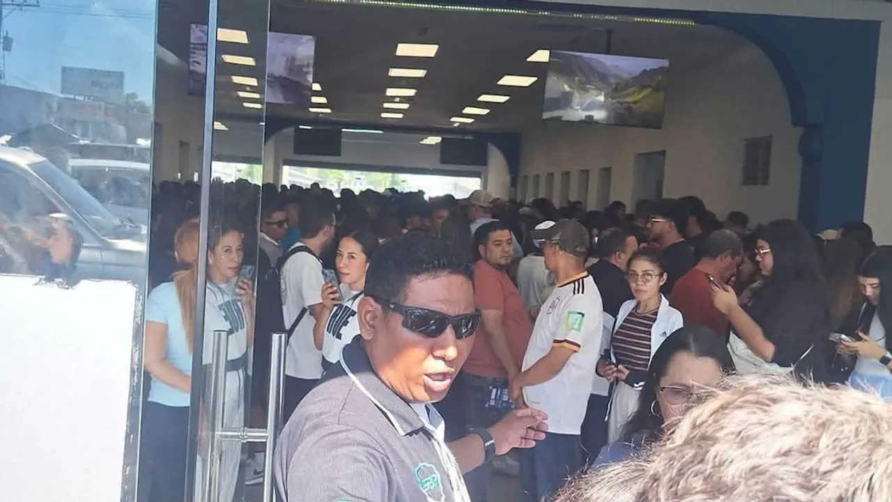 Multitud de personas espera aglomerada dentro de una terminal fronteriza para realizar trámites migratorios.