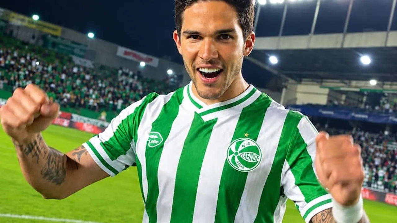 El futbolista Luis Amarilla festeja con una sonrisa y los puños en alto vistiendo la camiseta verde y blanca.