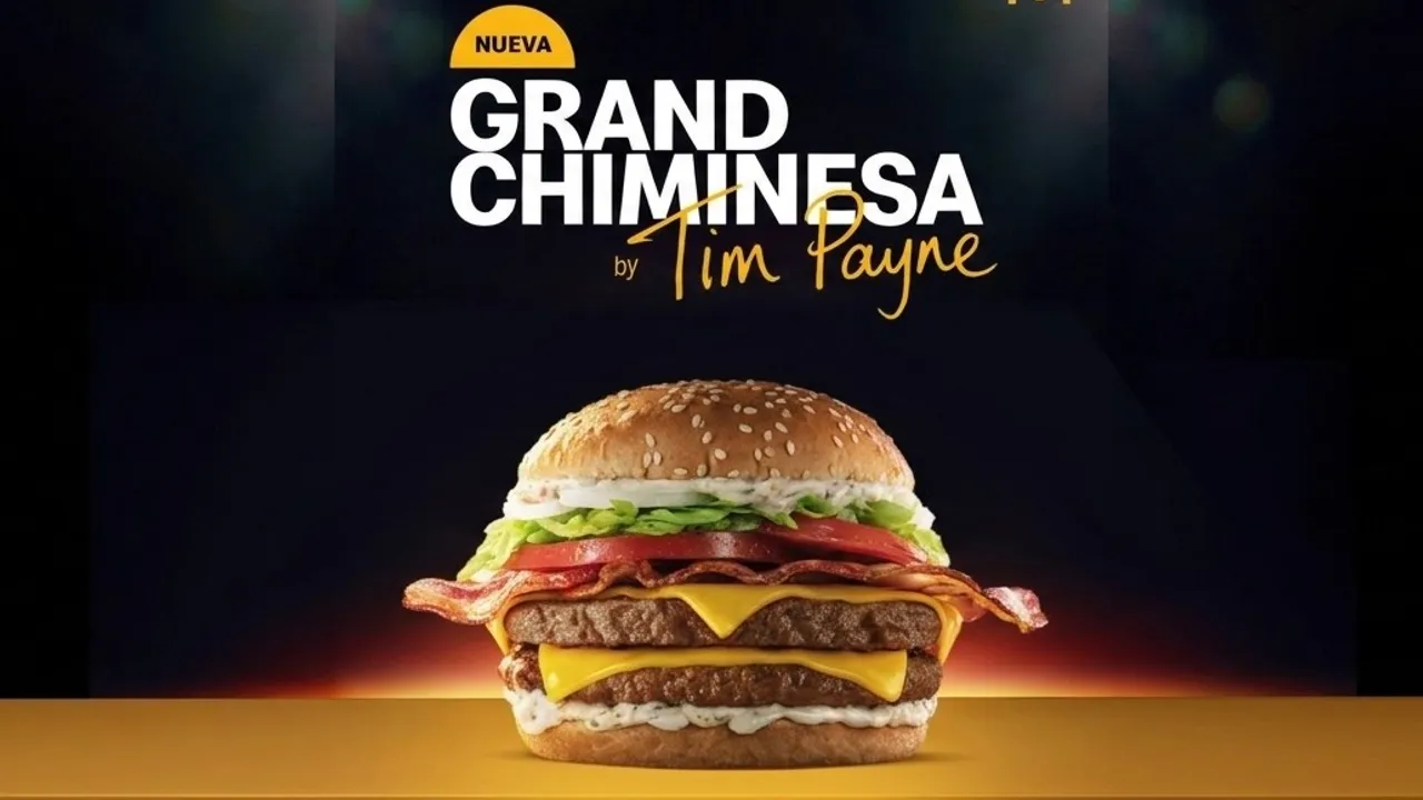 Hamburguesa con doble carne, queso cheddar, panceta, vegetales y salsa sobre fondo oscuro con texto publicitario.