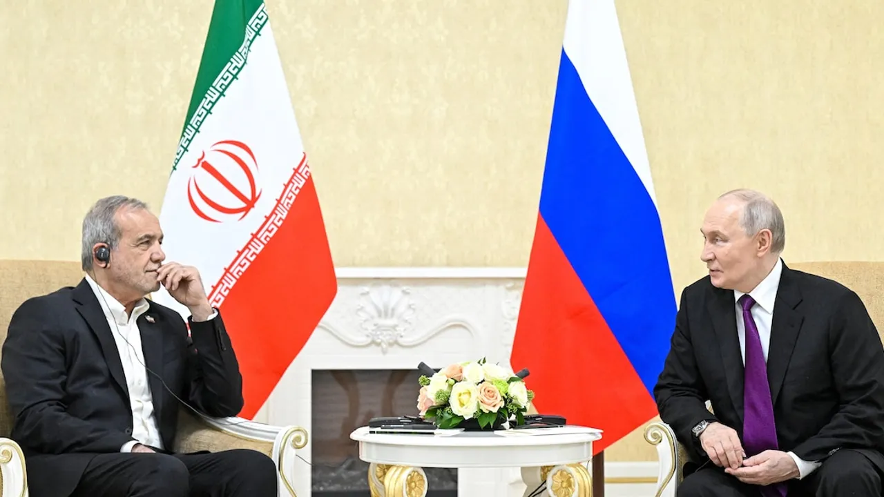 Masud Pezeshkian y Vladimir Putin conversan sentados frente a las banderas oficiales de Irán y Rusia