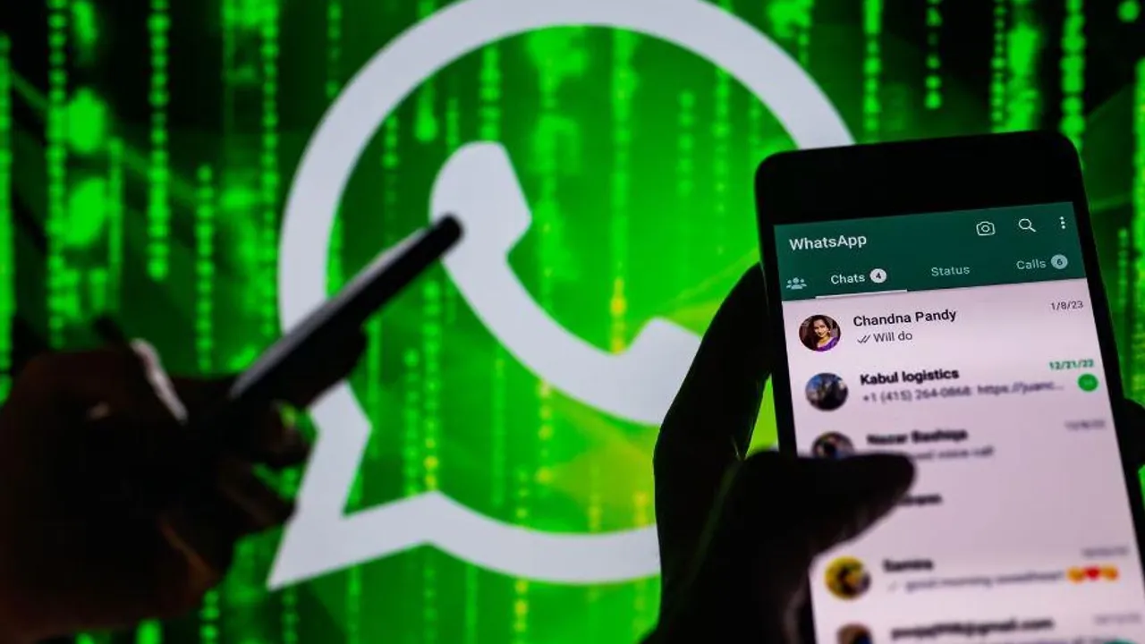 Teléfono celular con la aplicación WhatsApp en pantalla frente a un fondo digital verde de código binario.