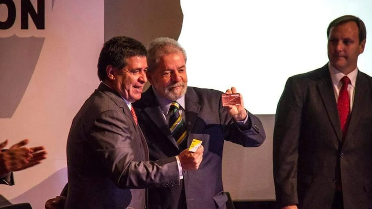 Horacio Cartes y Luiz Inácio Lula da Silva sonríen juntos mientras sostienen tarjetas durante un acto formal