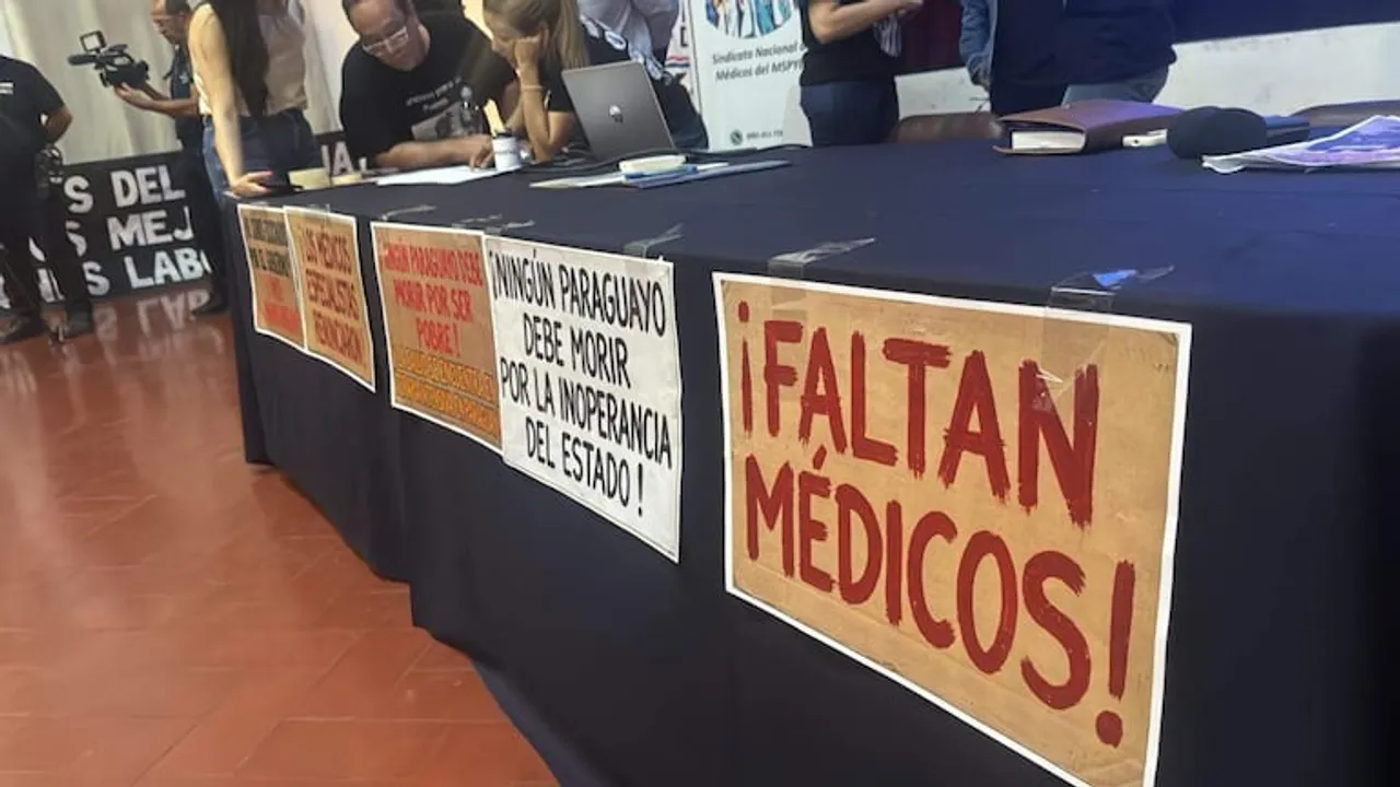 Mesa de conferencia con carteles de protesta que exigen más médicos y denuncian la inoperancia del Estado.