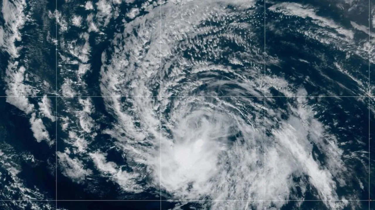 Vista satelital de una densa formación nubosa en espiral correspondiente a una tormenta sobre aguas del océano.