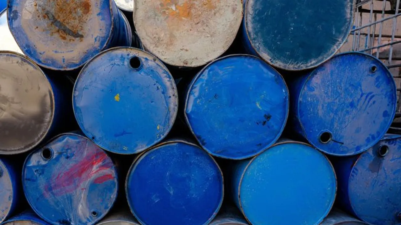 Tambores metálicos industriales de color azul y gris apilados en un depósito clandestino.