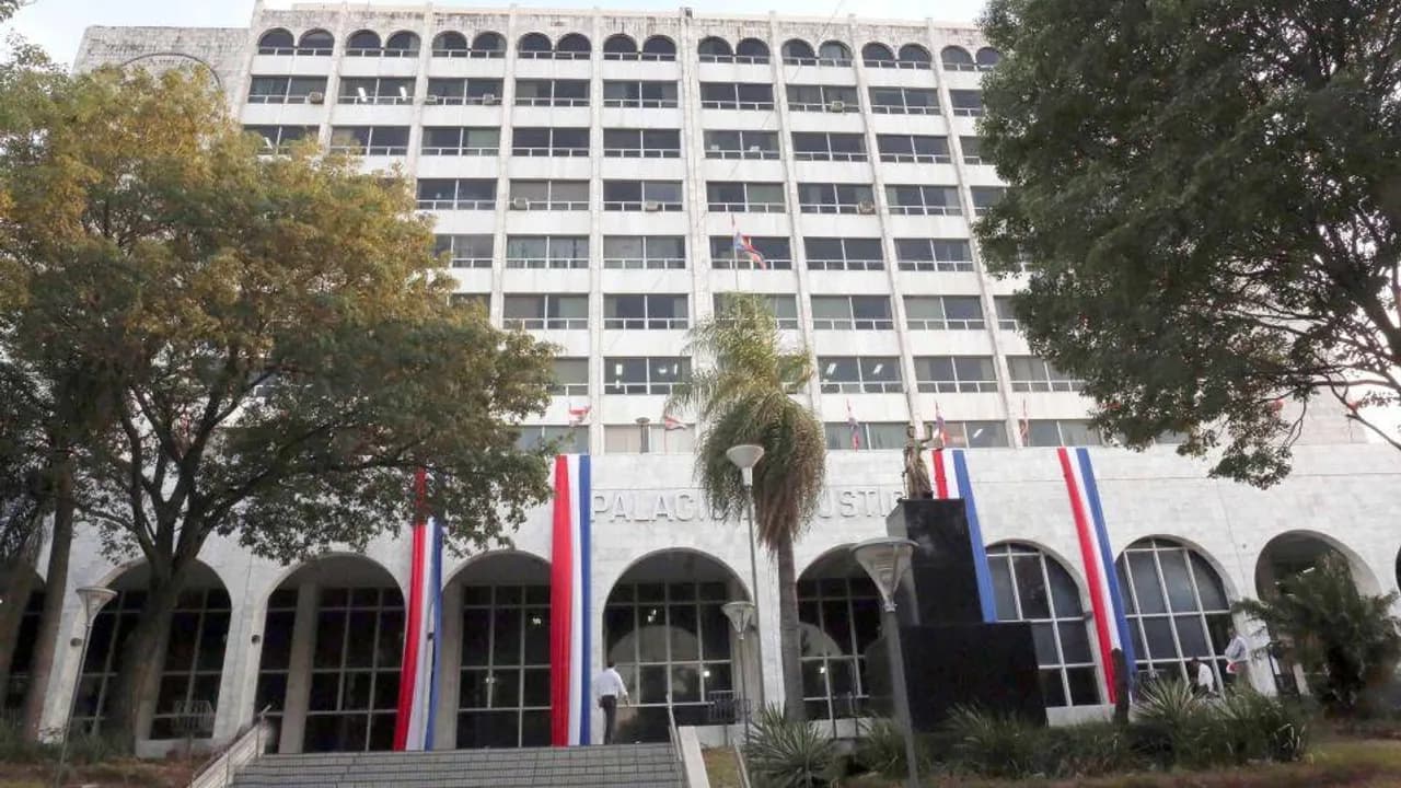 Fachada del Palacio de Justicia de Asunción con banderas paraguayas y palmeras en la entrada principal