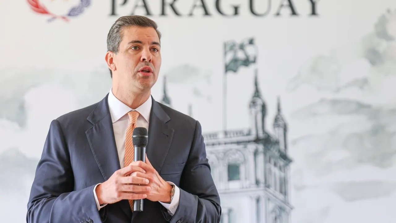 Santiago Peña hablando de traje con un micrófono en mano durante una conferencia de prensa institucional
