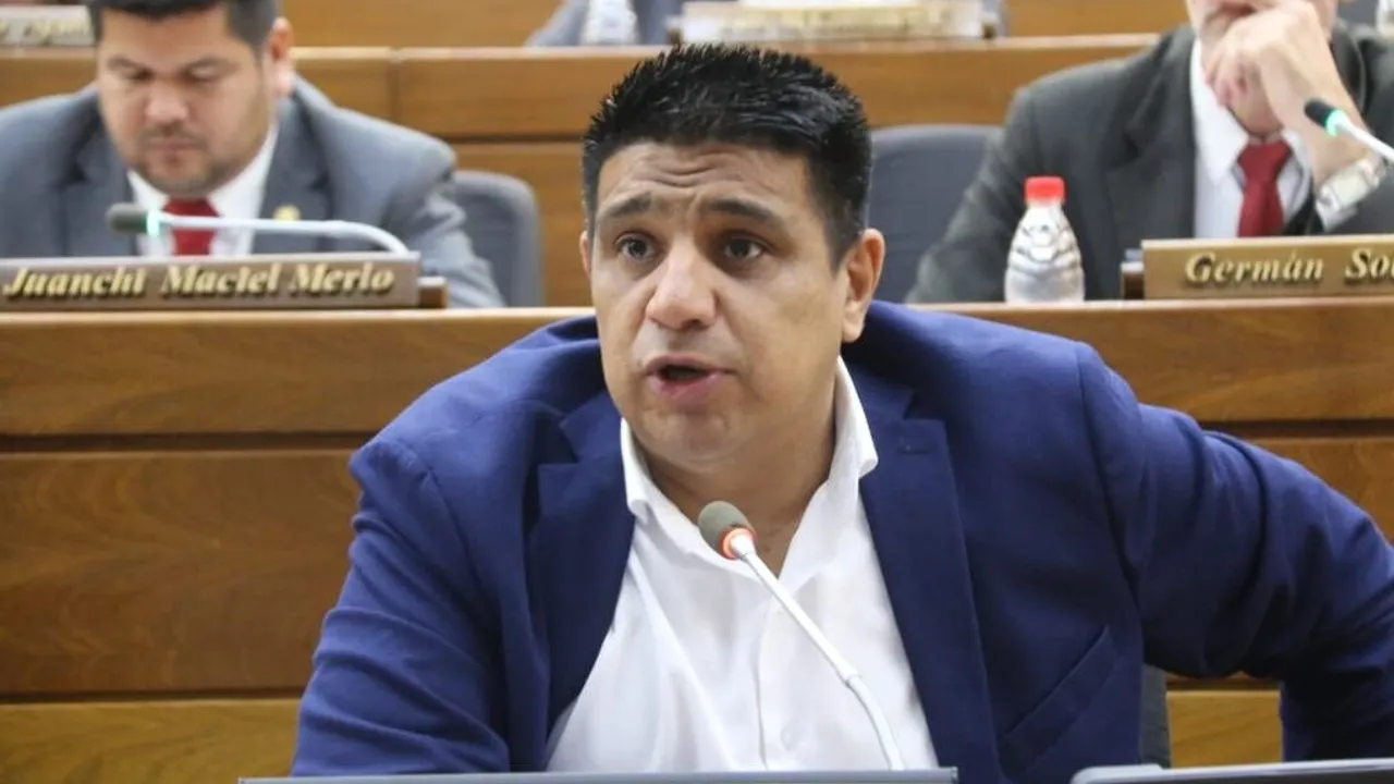 El diputado Hugo Meza viste saco azul y camisa blanca mientras habla ante un micrófono en la sala de sesiones.
