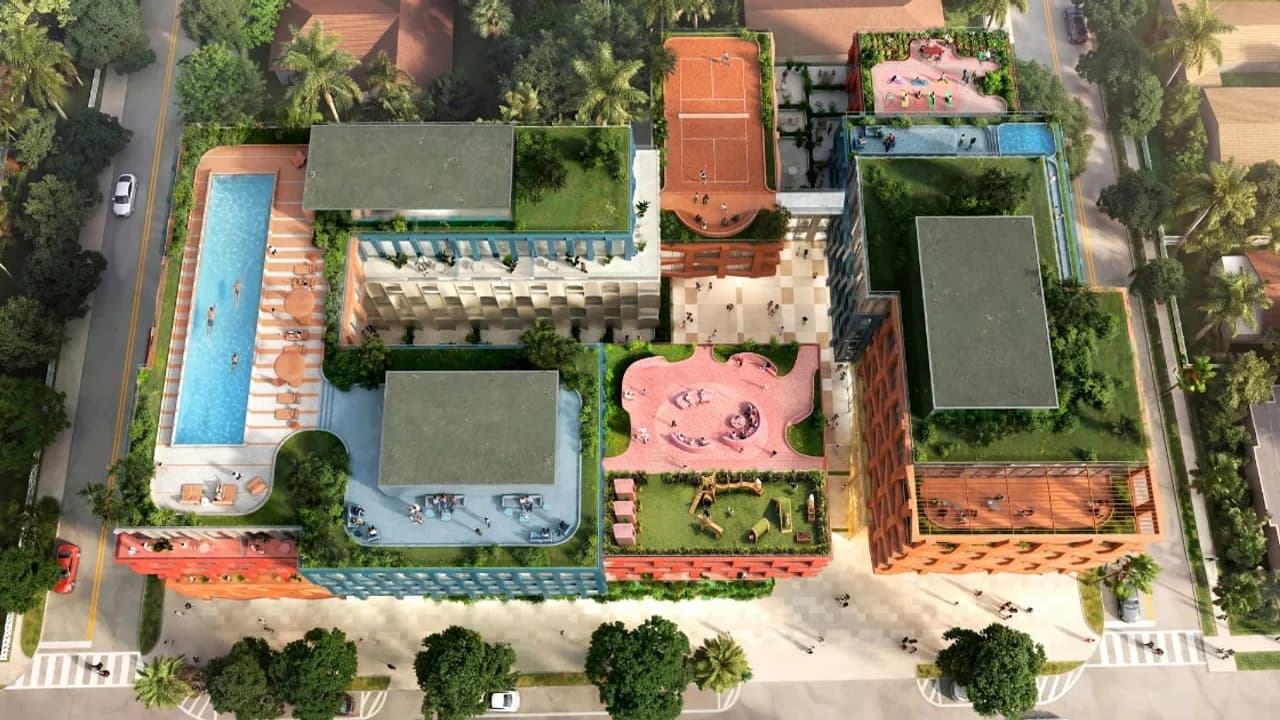 Vista aérea de complejo arquitectónico con terrazas verdes, cancha deportiva y piscina en la azotea sobre una calle urbana.