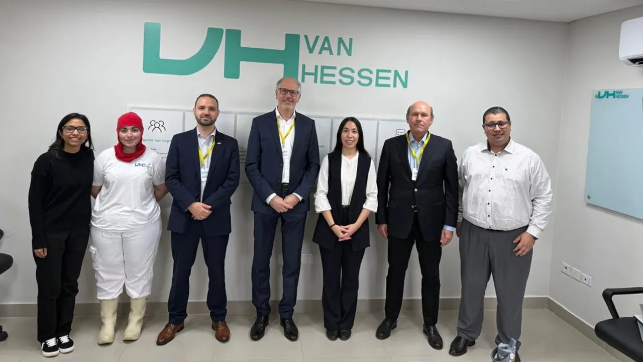 Siete personas posan de pie en una oficina frente a una pared blanca con el logotipo corporativo de Van Hessen.