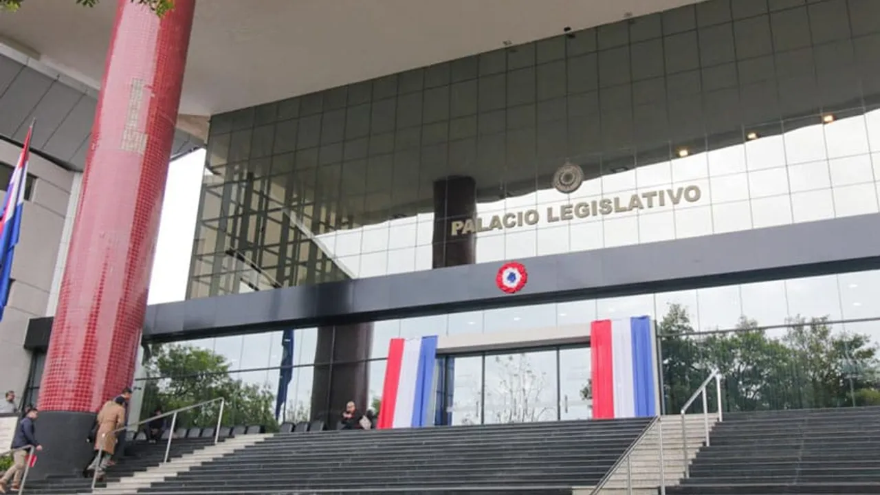 Escalinata y fachada de vidrio del Palacio Legislativo con los colores patrios en Asunción.