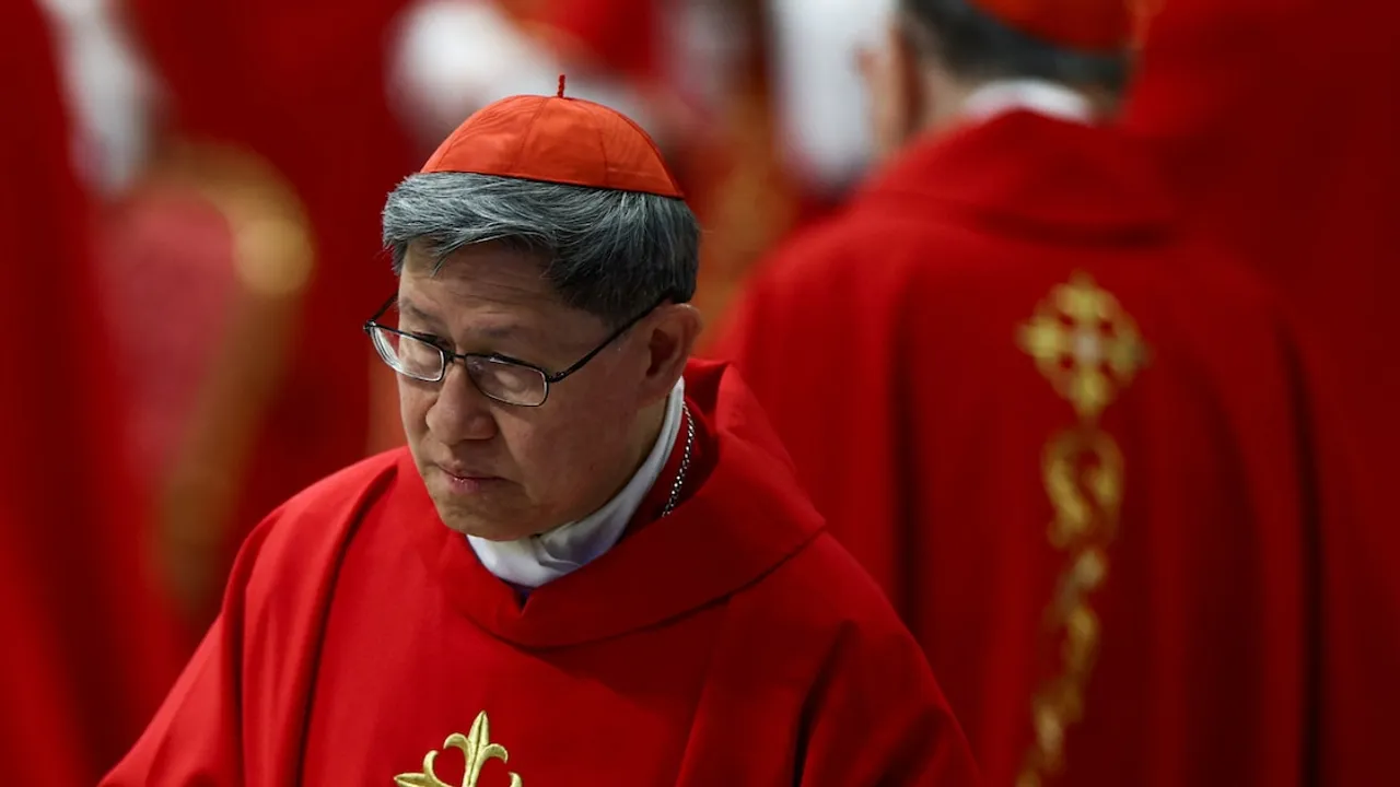 Cardenal con vestiduras litúrgicas rojas y solideo del mismo color mira hacia abajo durante un acto religioso.