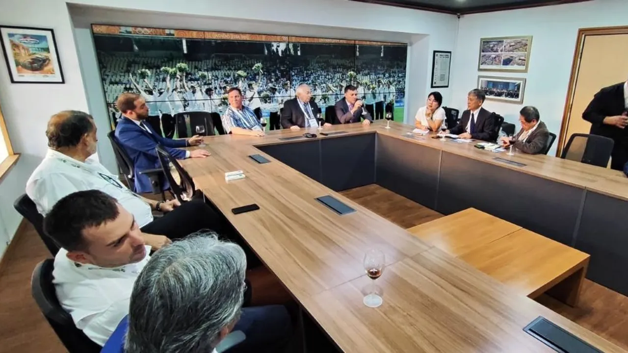 Empresarios y directivos sentados alrededor de una mesa de madera durante una reunión de negocios con copas de vino.