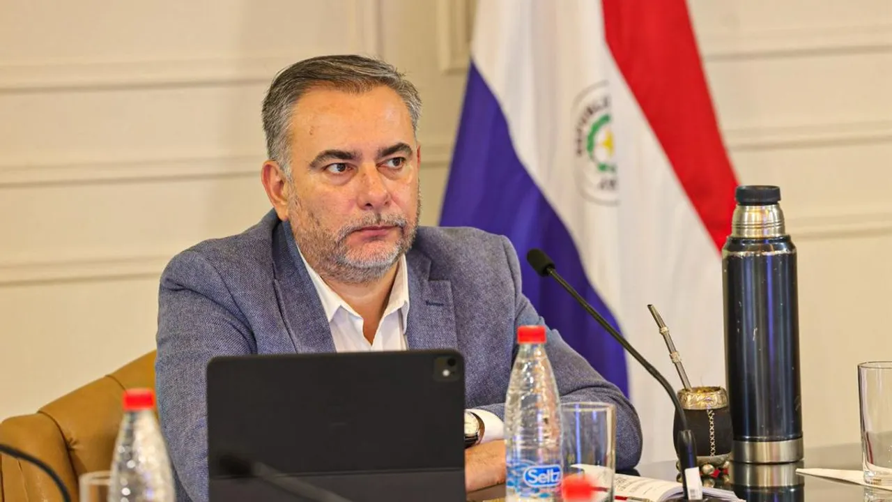 El senador Ever Villalba viste saco gris y mira al frente en una mesa de reuniones con micrófono y termo.